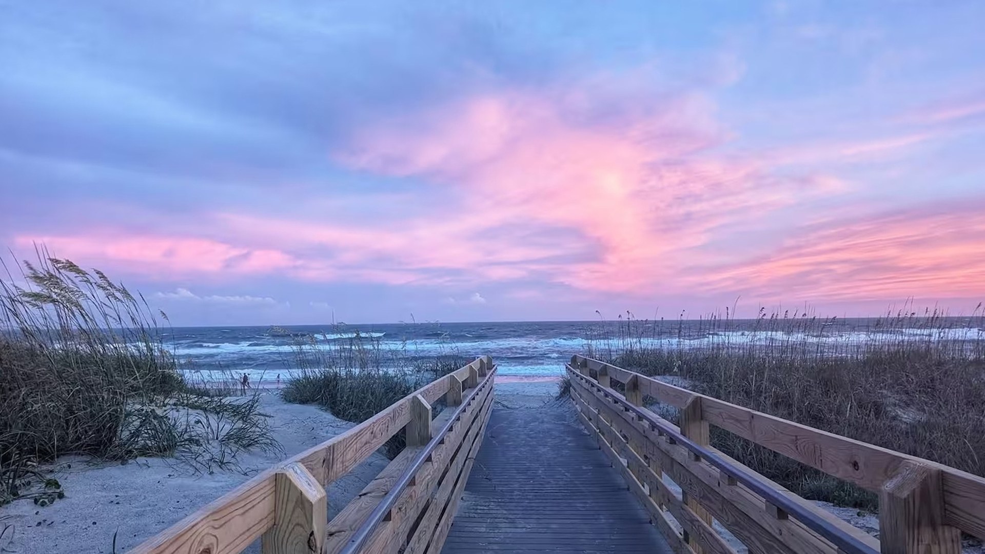 A boardwalk leading to the beach at sunset