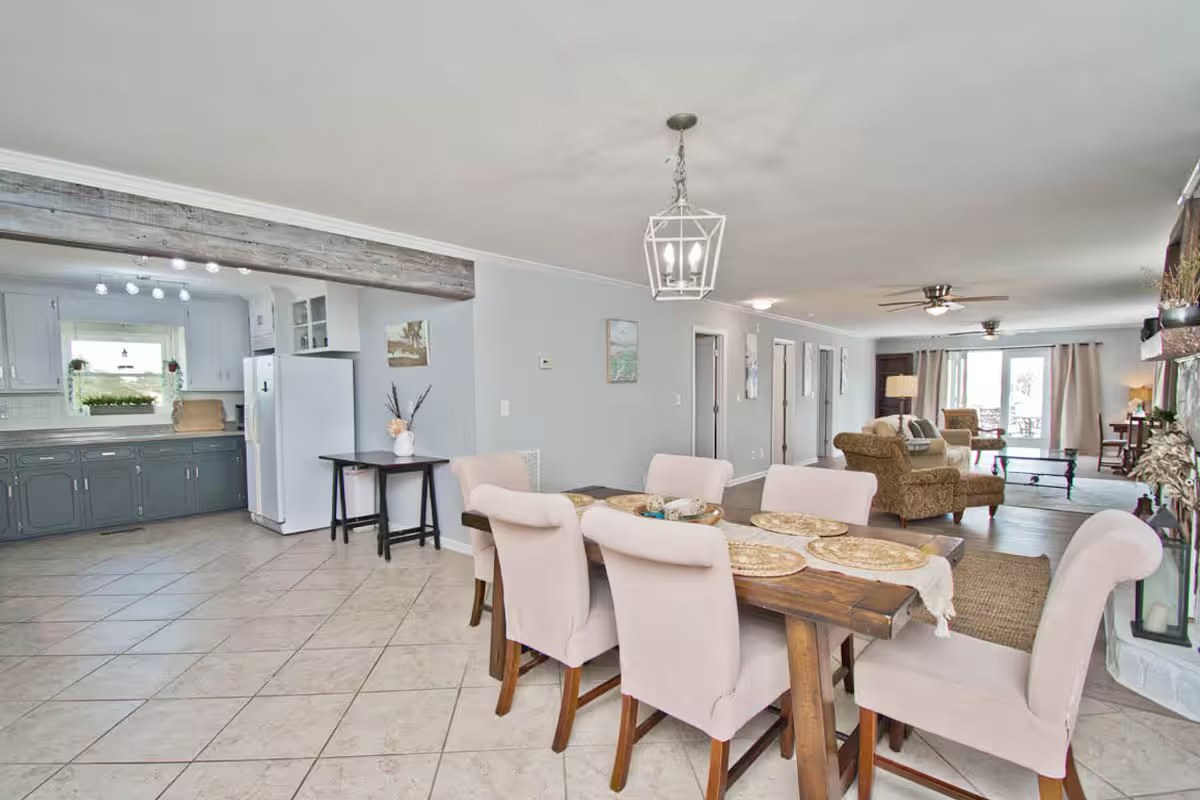 Dining table with kitchen and living room visible beyond