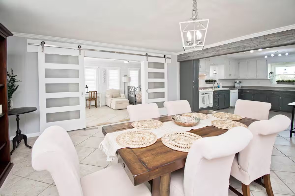 Dining table with sliding glass barn doors to the sunroom