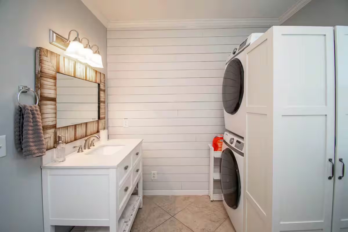 Main bathroom vanity with stacked washer and dryer
