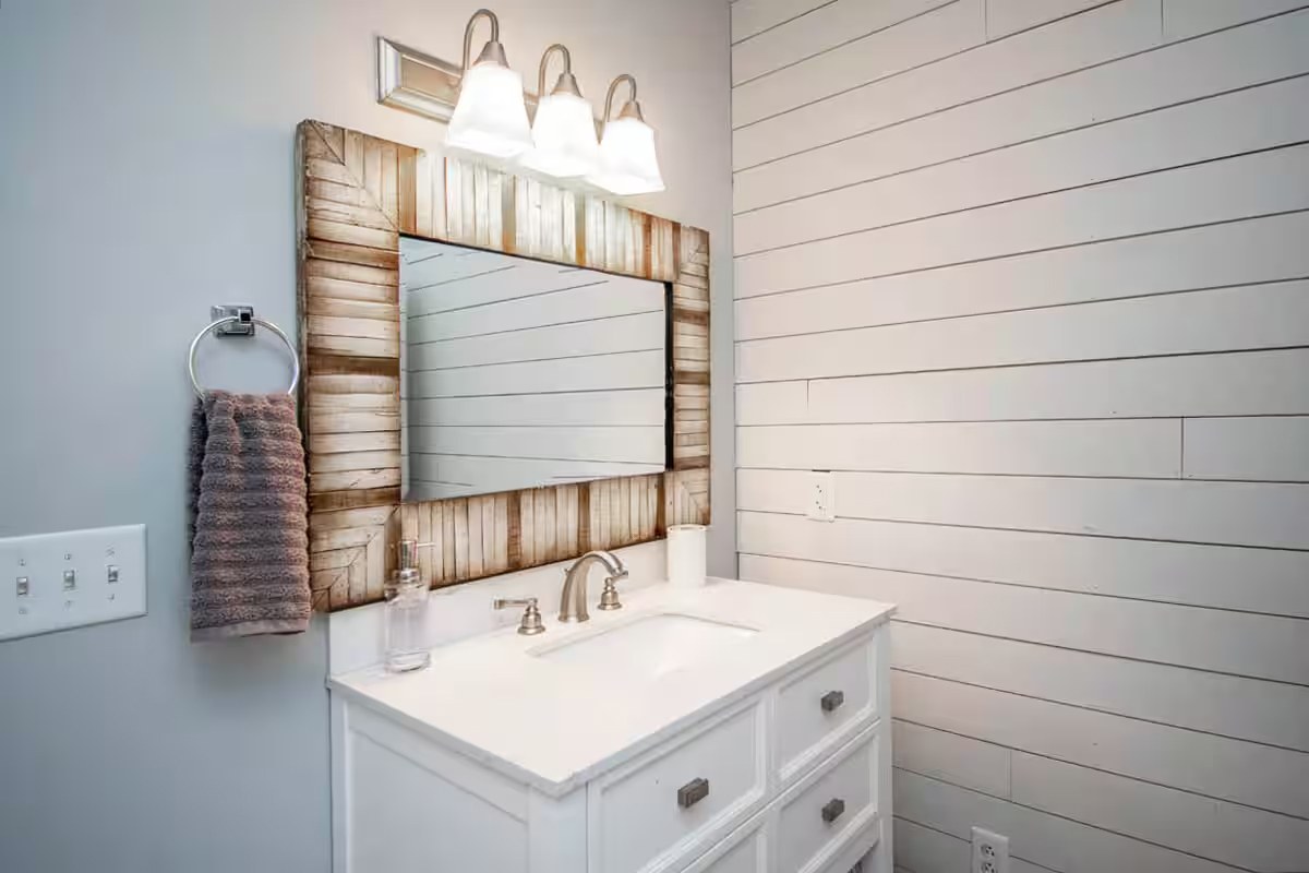 Main bathroom vanity with rustic wood-framed mirror