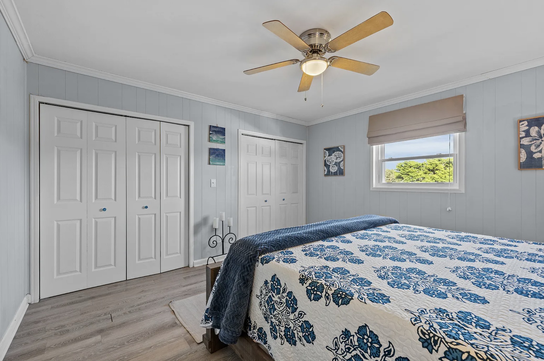 King bedroom with blue floral quilt and double closets