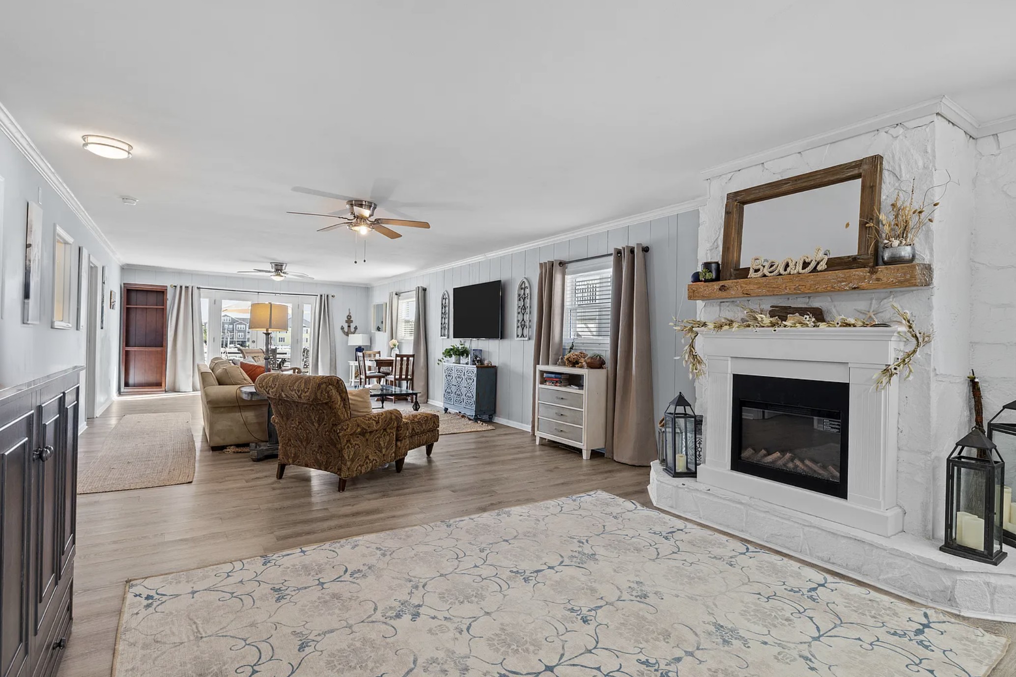 Living room view toward the stone fireplace and dining area beyond