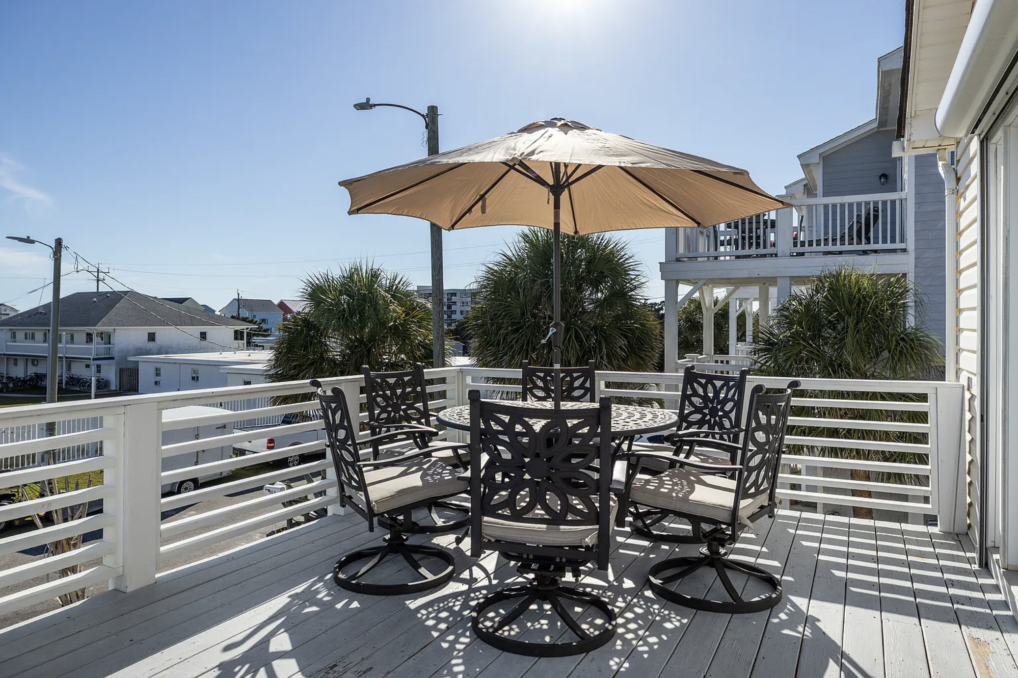 Upper deck with round table, swivel chairs, and umbrella