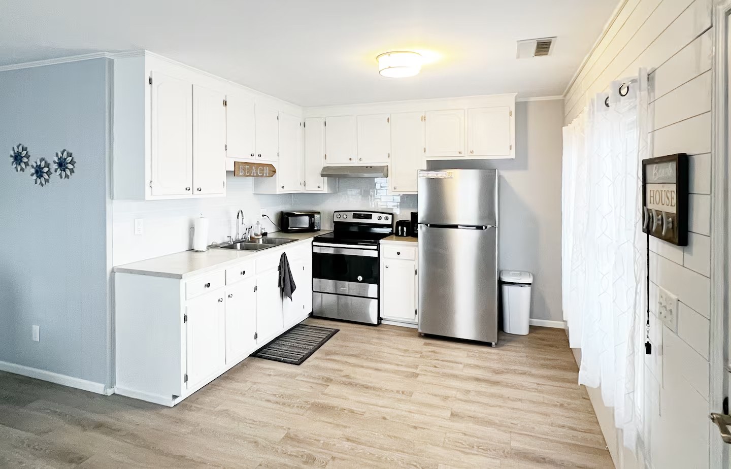Kitchen counter and cabinetry with Beach sign