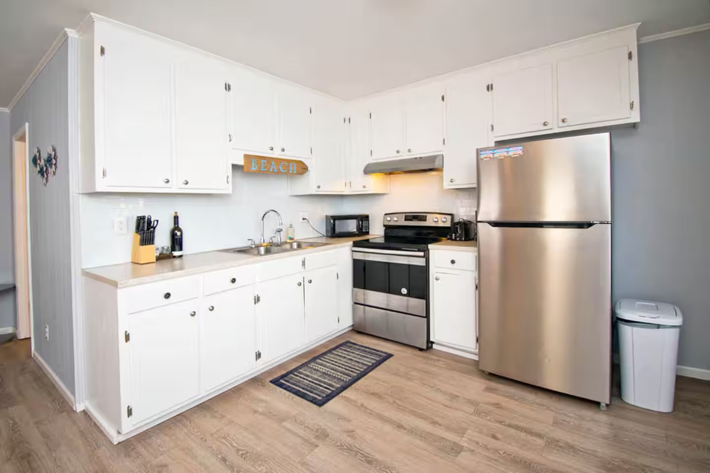 Kitchen view toward stainless refrigerator and windows