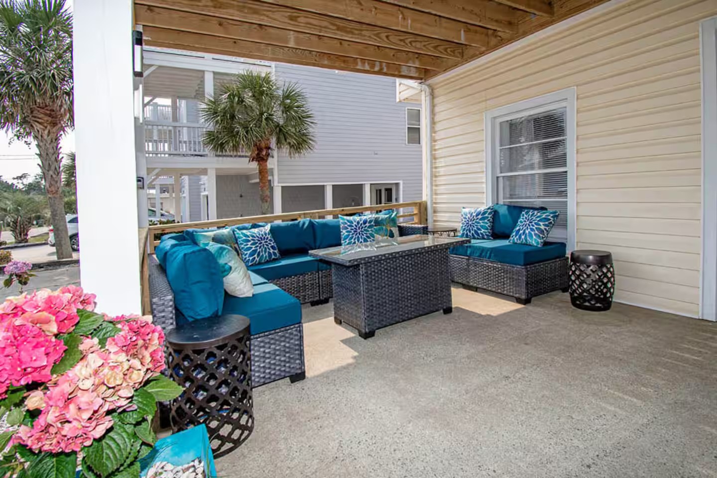 Covered patio sectional with hydrangeas and neighboring homes in view
