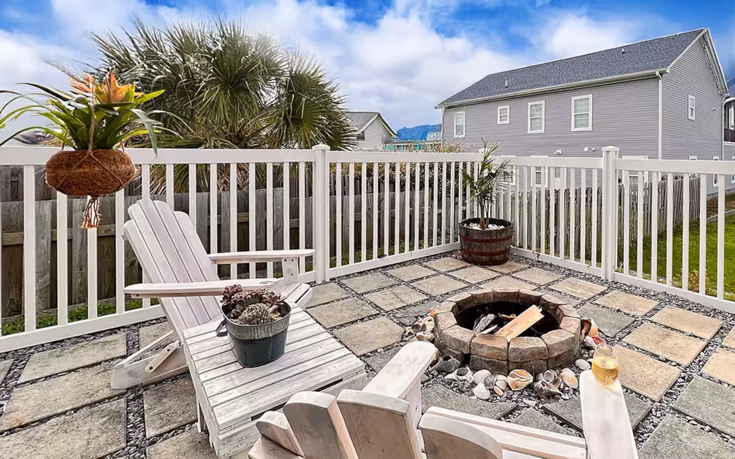 Fire pit patio with Adirondack chairs and string of shells