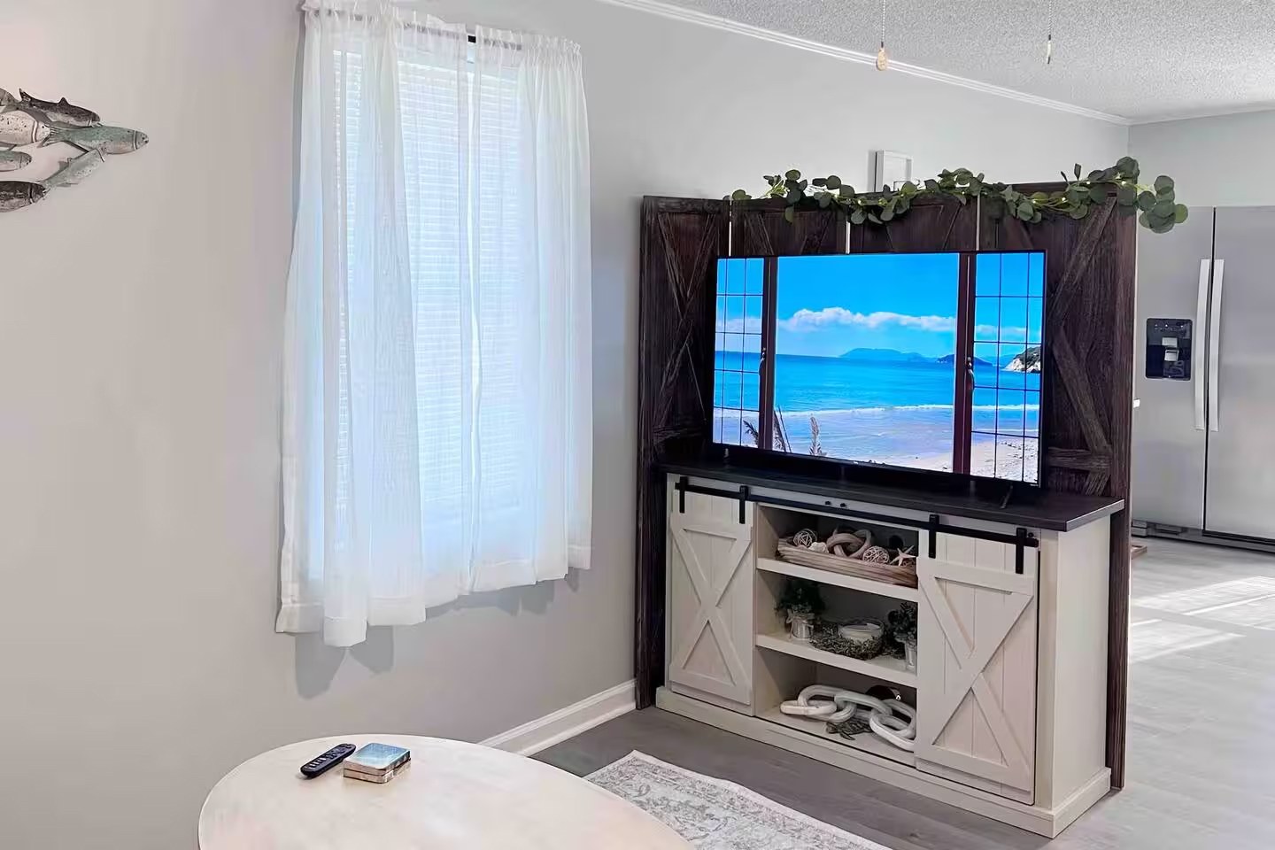 TV cabinet with sliding barn doors and ocean view on screen